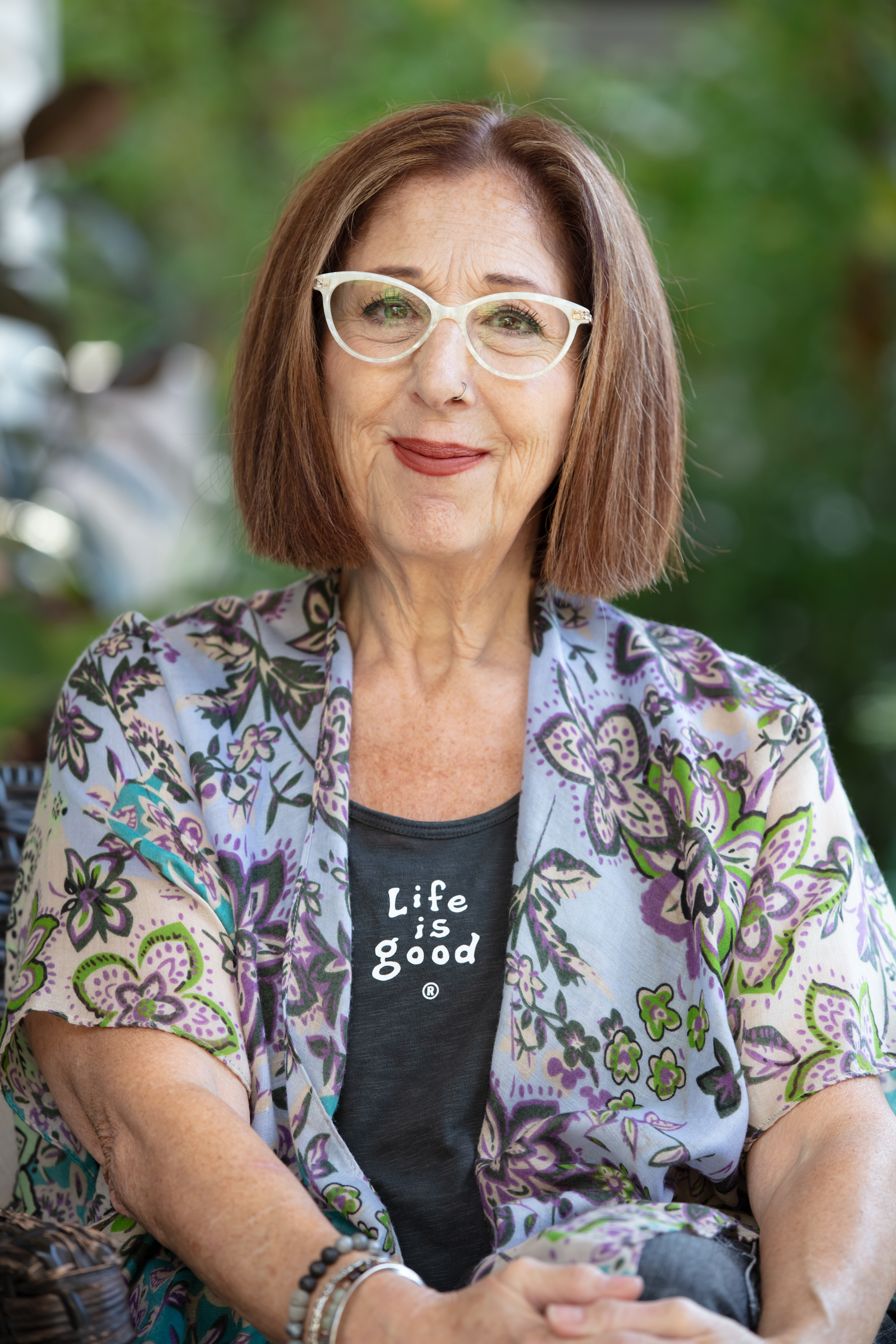 Patti Katz Black seated outdoors wearing a colorful floral wrap
